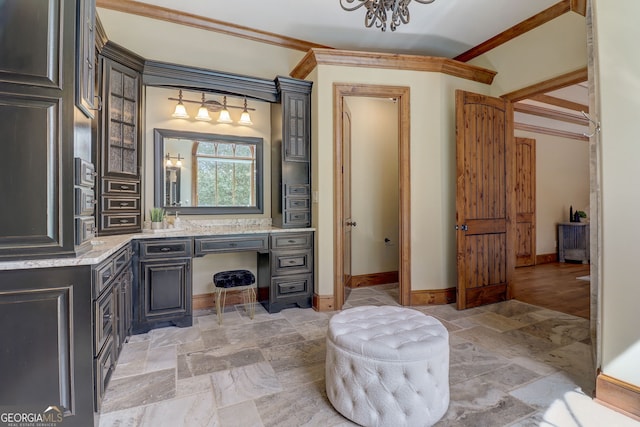 bathroom with tile floors, ornamental molding, vanity, and a chandelier