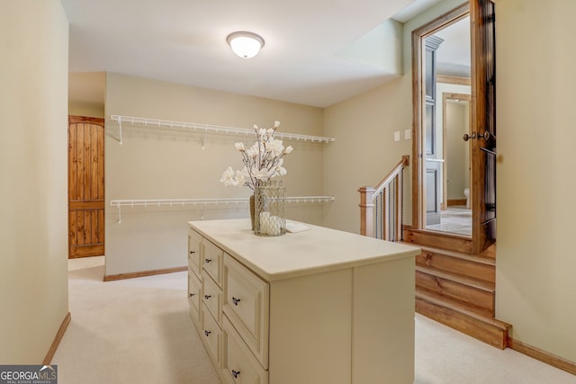 walk in closet featuring light carpet