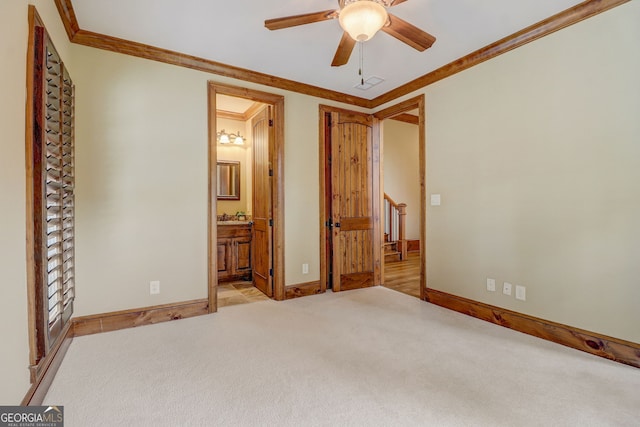 unfurnished bedroom featuring ceiling fan, ornamental molding, light carpet, and ensuite bathroom