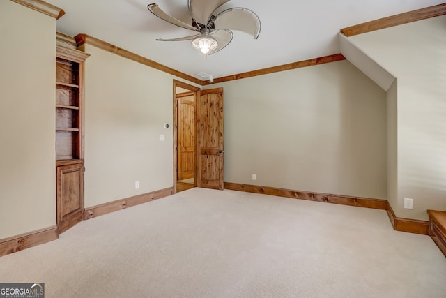 spare room featuring light colored carpet, ceiling fan, and ornamental molding