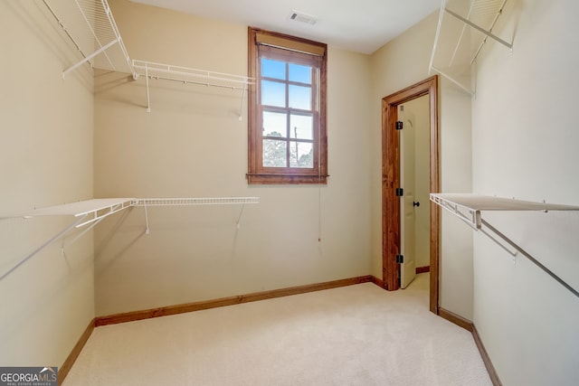 walk in closet featuring light colored carpet