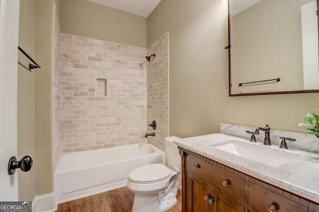 full bathroom featuring toilet, vanity, tiled shower / bath, and hardwood / wood-style flooring