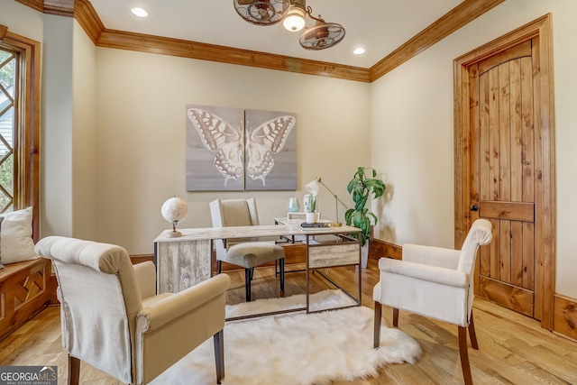 living area with an inviting chandelier, crown molding, and light wood-type flooring