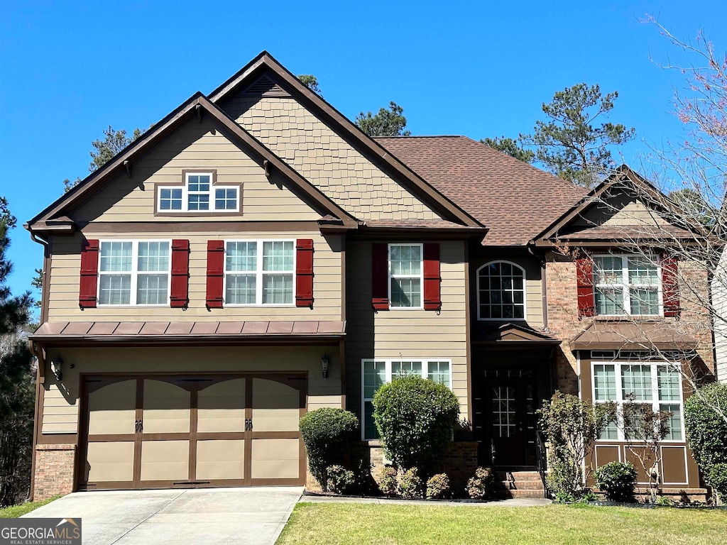 craftsman house with a front lawn and a garage