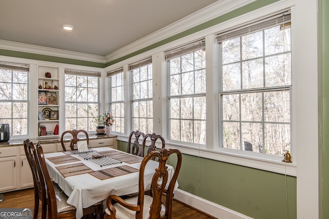 dining area with built in shelves, a healthy amount of sunlight, ornamental molding, and hardwood / wood-style floors