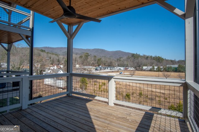 wooden terrace with a mountain view and ceiling fan