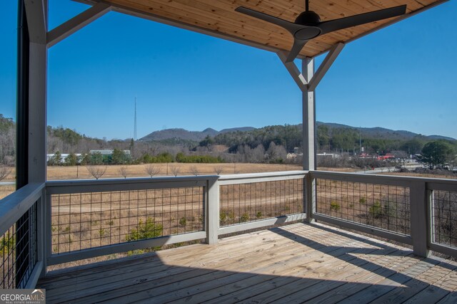 wooden terrace featuring a mountain view and ceiling fan