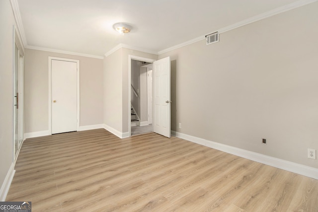 unfurnished bedroom featuring a closet, crown molding, and light wood-type flooring