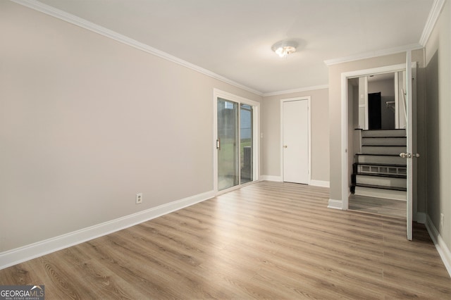 spare room featuring crown molding and light hardwood / wood-style flooring