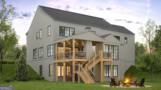 back of house featuring an outdoor fire pit, stairway, a lawn, and stucco siding