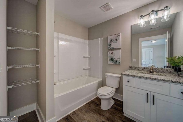 full bathroom featuring wood-type flooring, oversized vanity, toilet, and washtub / shower combination