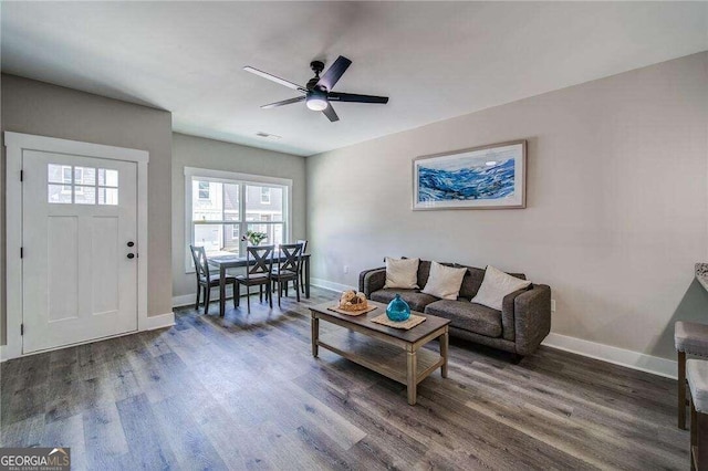 living room with ceiling fan and dark wood-type flooring