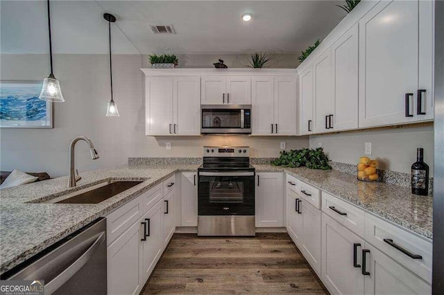 kitchen featuring light stone countertops, decorative light fixtures, stainless steel appliances, dark hardwood / wood-style floors, and white cabinetry