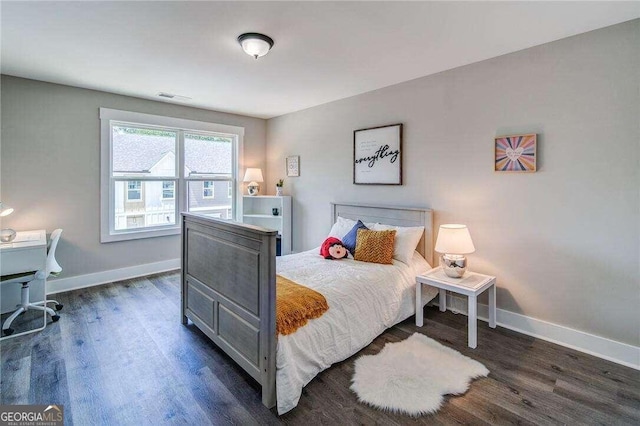 bedroom with dark hardwood / wood-style floors