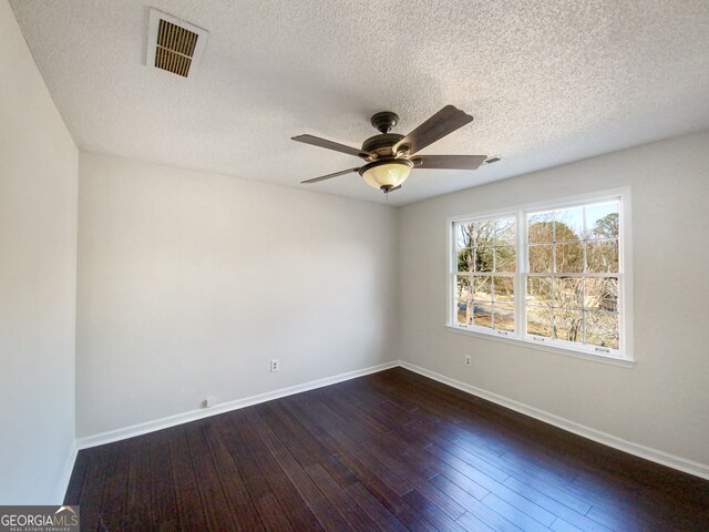 unfurnished room with a textured ceiling, dark hardwood / wood-style flooring, and ceiling fan