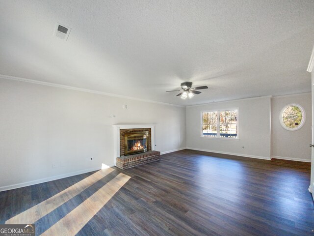 unfurnished living room with crown molding, dark wood-type flooring, a fireplace, and a textured ceiling