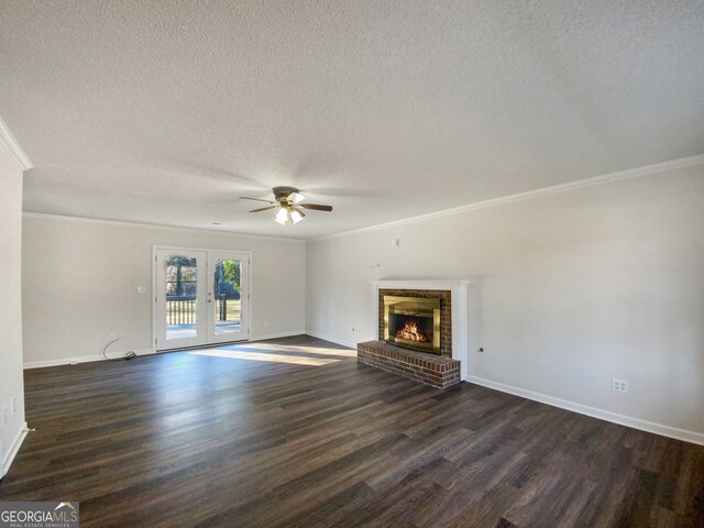 unfurnished living room featuring ornamental molding, a fireplace, dark wood-type flooring, and a textured ceiling