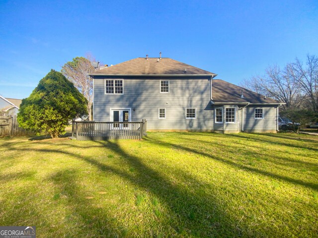 rear view of property featuring a yard and a deck