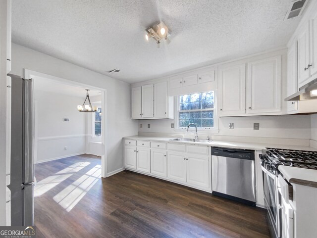 kitchen with dark hardwood / wood-style flooring, white cabinets, sink, and stainless steel appliances