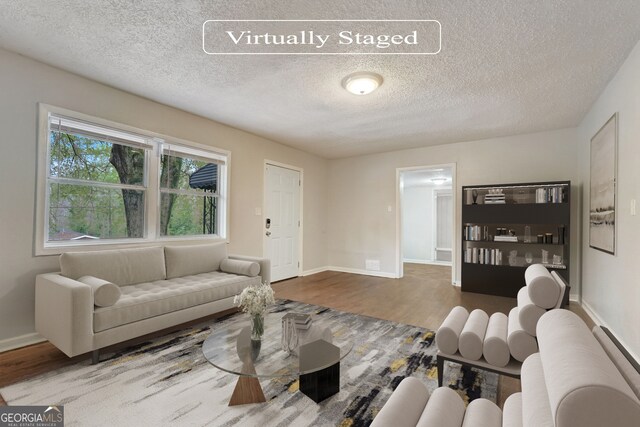 living room with dark hardwood / wood-style flooring and a textured ceiling