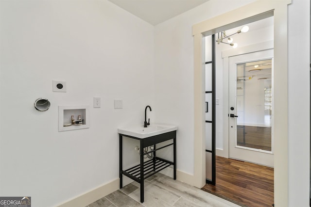 clothes washing area with hookup for a washing machine, light wood-type flooring, an inviting chandelier, and electric dryer hookup