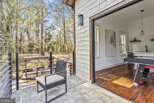 view of patio with a balcony and beverage cooler