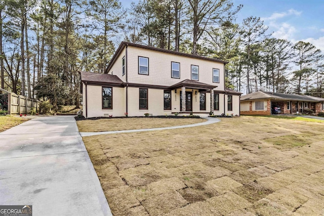 view of front of house with covered porch and a front lawn