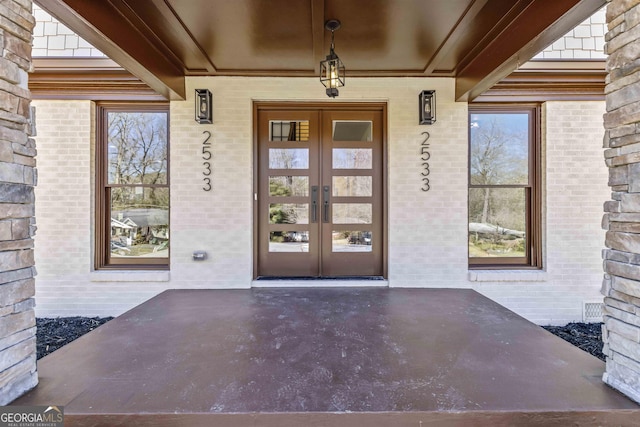 entrance to property featuring covered porch and french doors