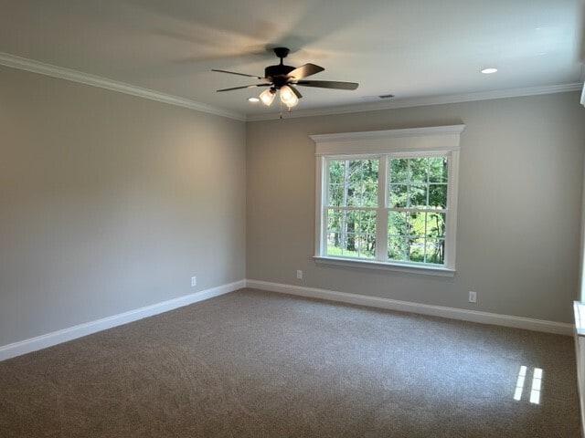 carpeted empty room with ceiling fan and crown molding