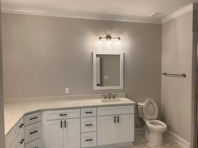 bathroom featuring tile floors, oversized vanity, toilet, and crown molding