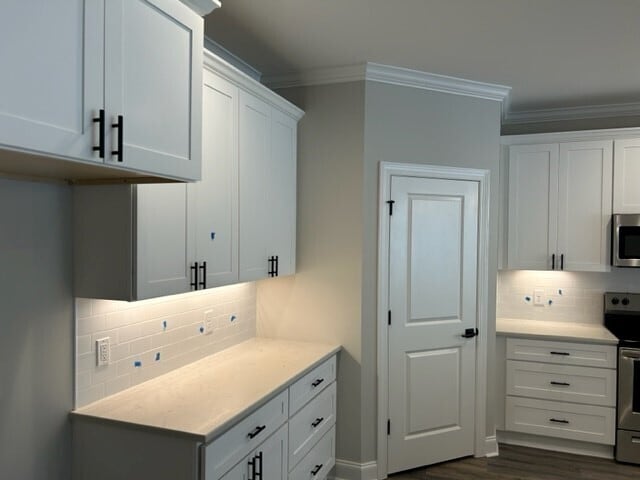 kitchen featuring white cabinets, range with electric cooktop, backsplash, and dark hardwood / wood-style flooring