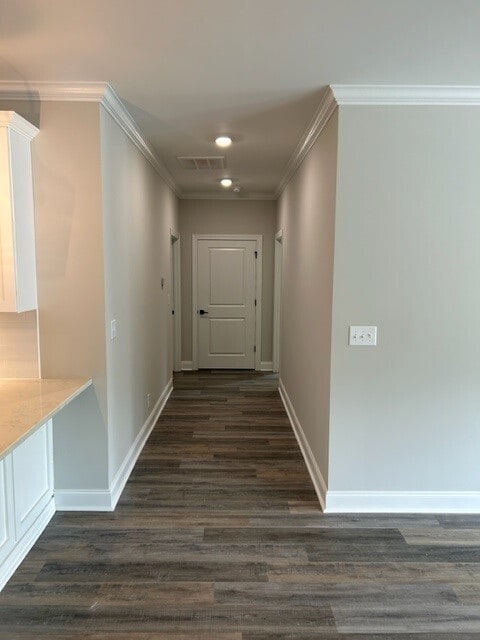 hall featuring ornamental molding and dark wood-type flooring