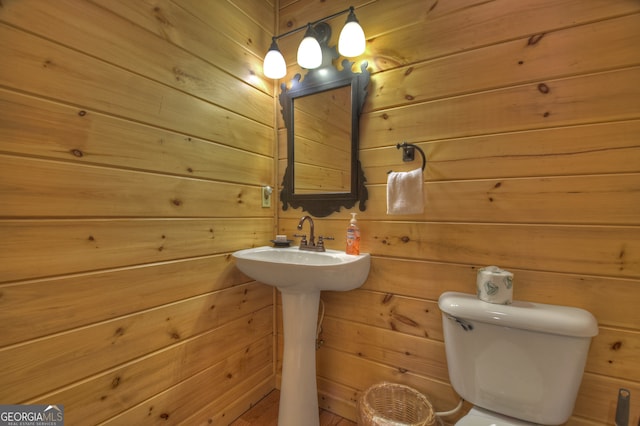 bathroom with toilet and wooden walls