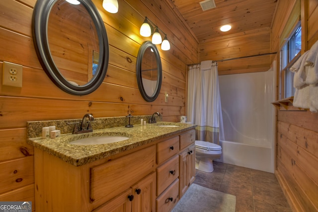 full bathroom with vanity, toilet, and wood walls