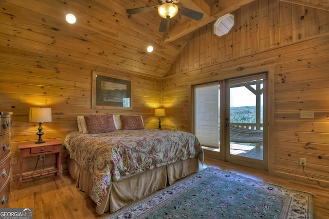 bedroom with access to outside, ceiling fan, wooden walls, high vaulted ceiling, and light hardwood / wood-style flooring