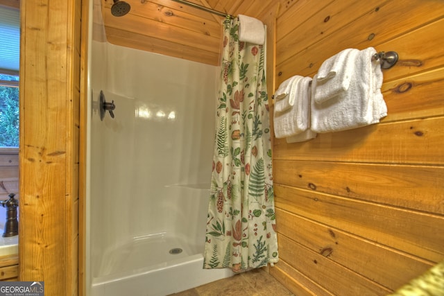 bathroom with wooden walls, wooden ceiling, and walk in shower