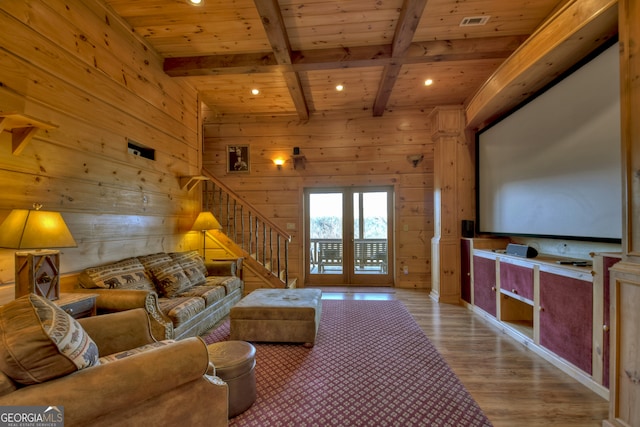 living room featuring french doors, beamed ceiling, wooden ceiling, light hardwood / wood-style floors, and wood walls