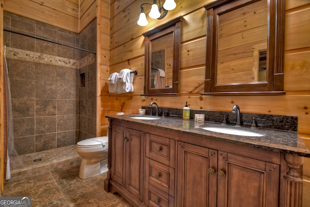 bathroom featuring vanity, a tile shower, toilet, and wood walls