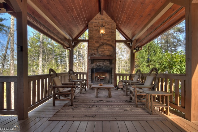 wooden terrace with an outdoor stone fireplace