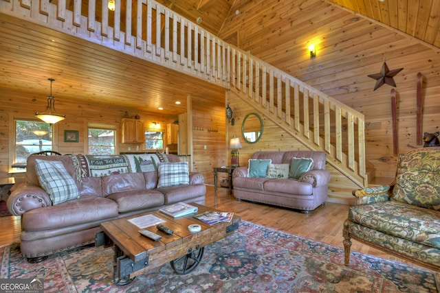 living room featuring wooden walls, light hardwood / wood-style flooring, high vaulted ceiling, and wooden ceiling