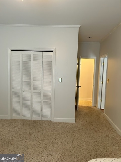 unfurnished bedroom featuring crown molding and a closet