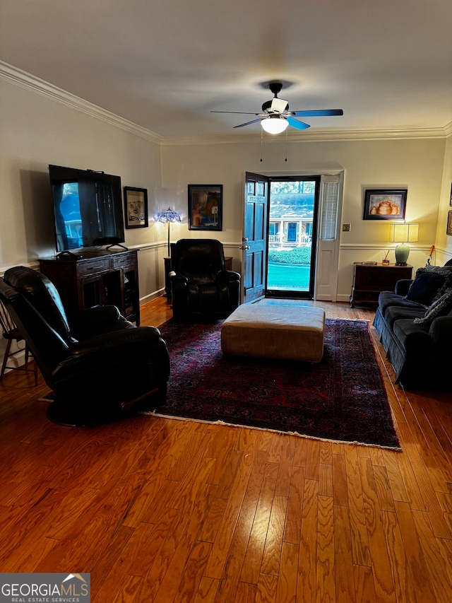 living room with hardwood / wood-style floors, crown molding, and ceiling fan