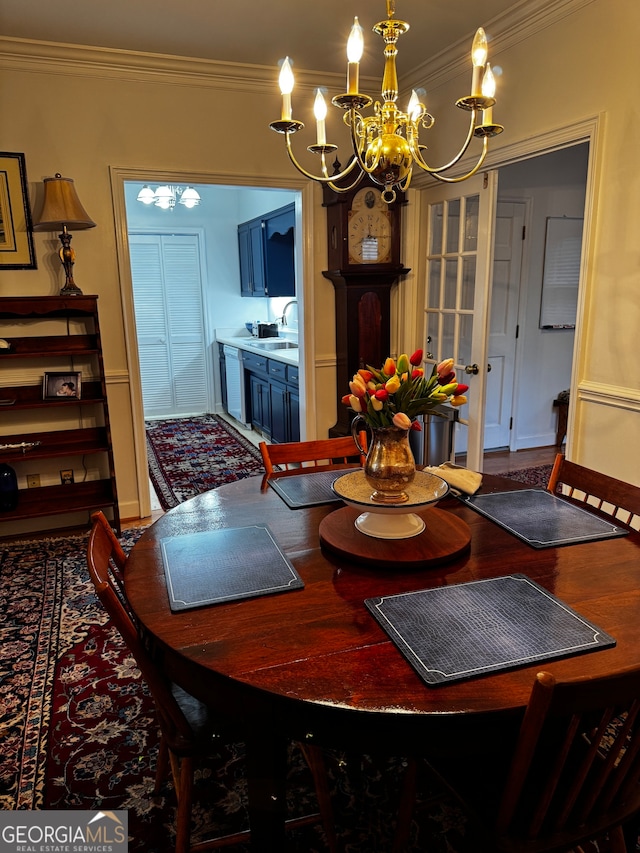 dining room with a notable chandelier, ornamental molding, and sink