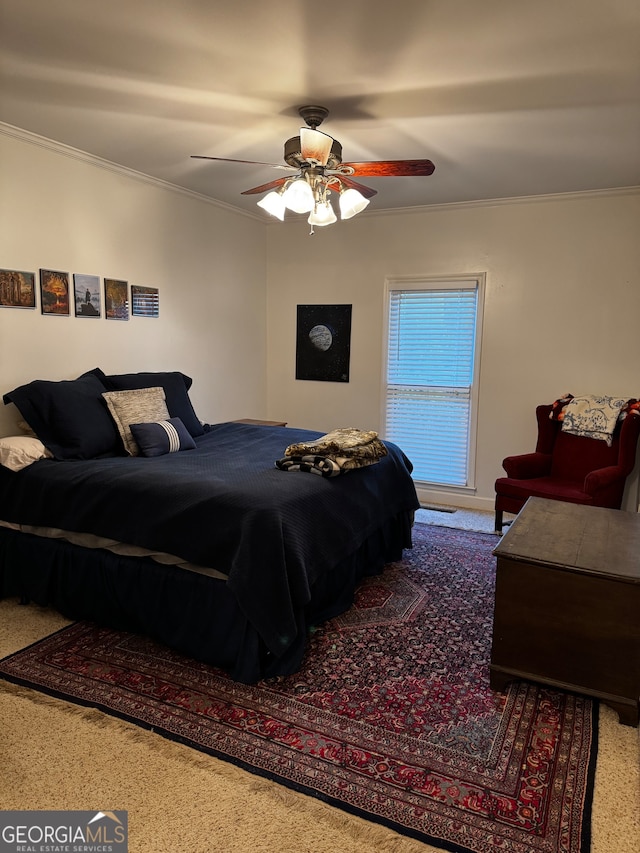 carpeted bedroom with ceiling fan and ornamental molding