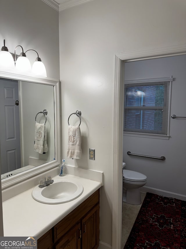 bathroom featuring vanity, toilet, crown molding, and tile patterned floors