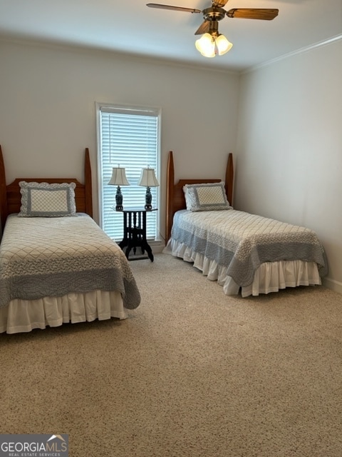 bedroom featuring ceiling fan, ornamental molding, and carpet floors