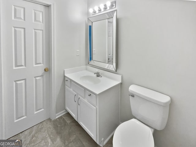 half bath featuring vanity and toilet