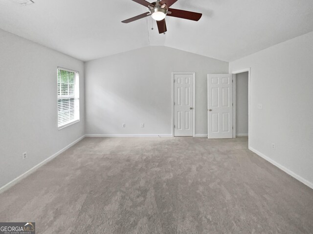 interior space featuring carpet floors, baseboards, ceiling fan, and vaulted ceiling
