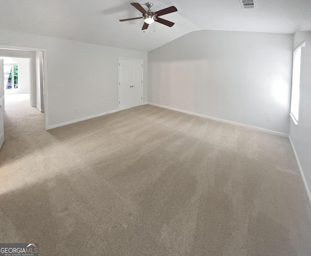 carpeted spare room featuring ceiling fan and lofted ceiling