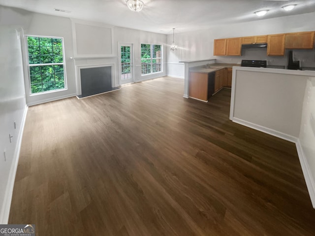 kitchen featuring stove, a healthy amount of sunlight, sink, a chandelier, and dark hardwood / wood-style floors